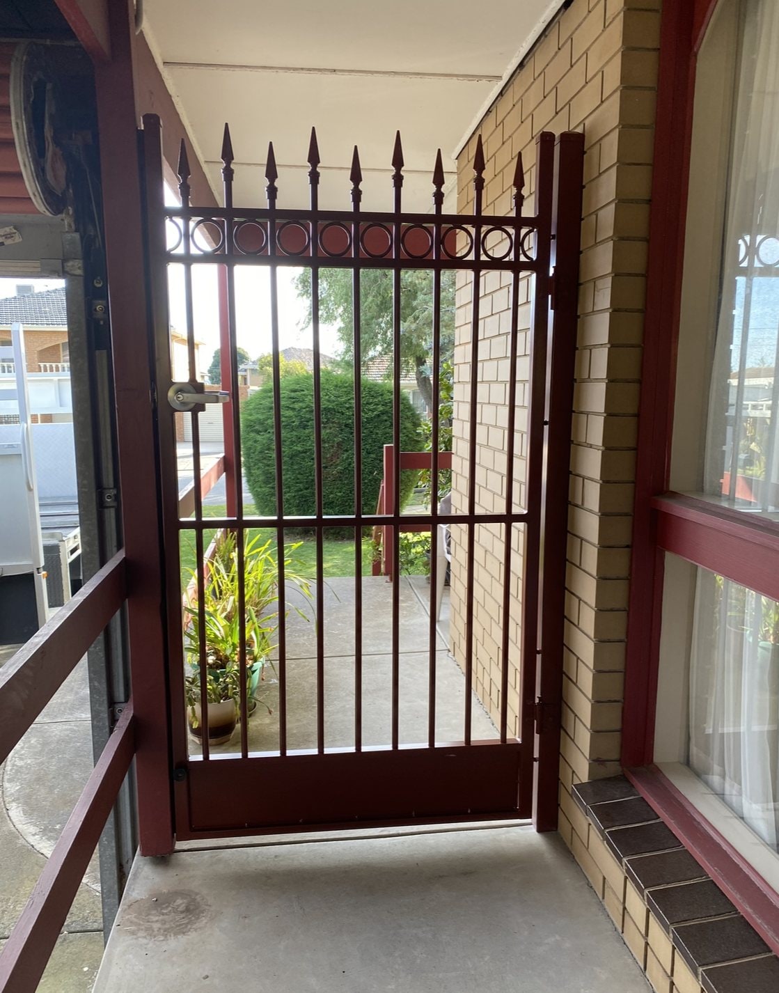 Red-brown spear-top metal pedestrian gate