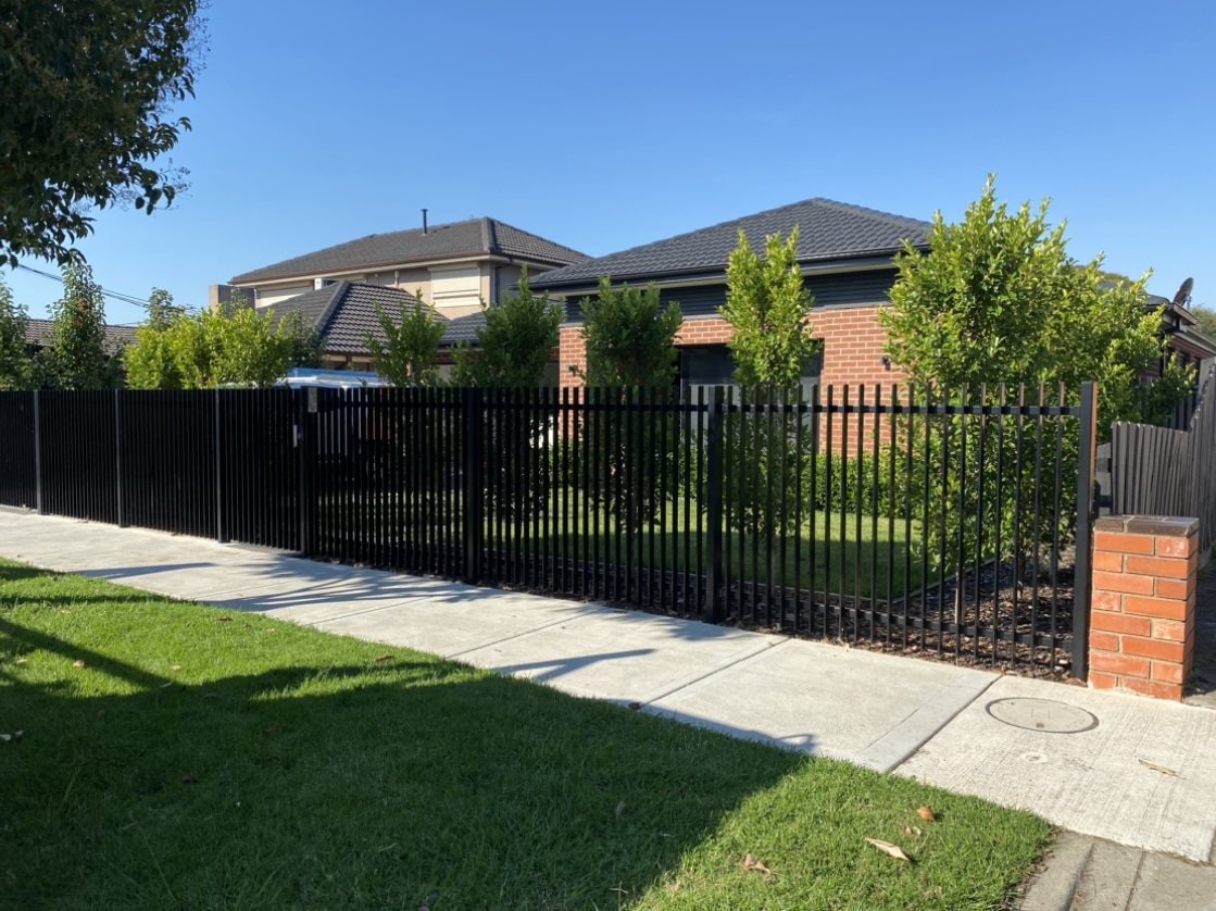 Black metal palisade front fence and lawn