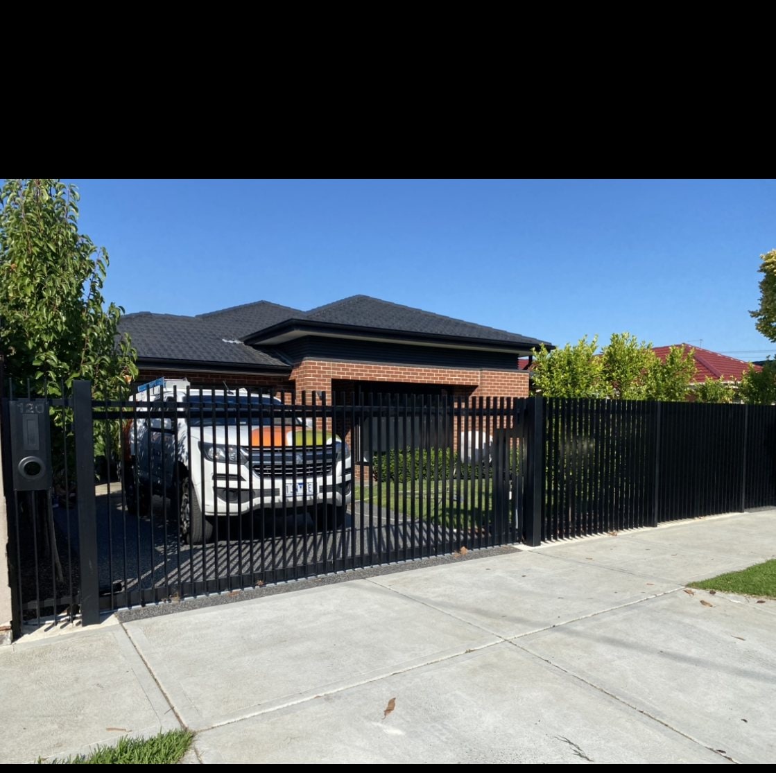 Black palisade fence and automated driveway gate