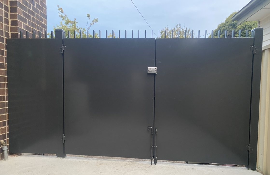 Black solid metal privacy gates in a rear yard