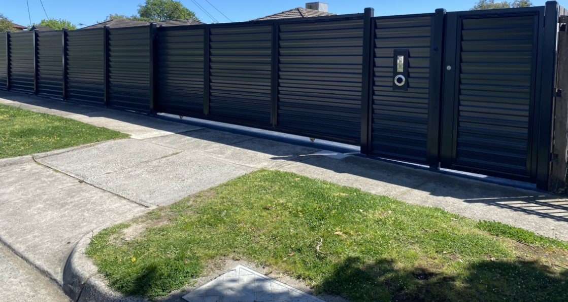 Dark horizontal slat privacy fence with pedestrian gate