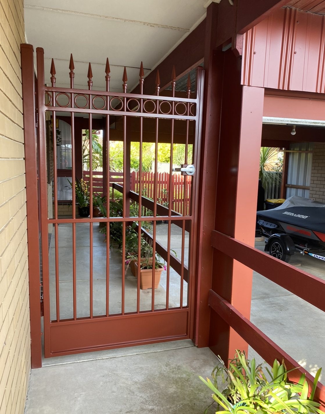 Powder-coated spear-top pedestrian gate under a verandah