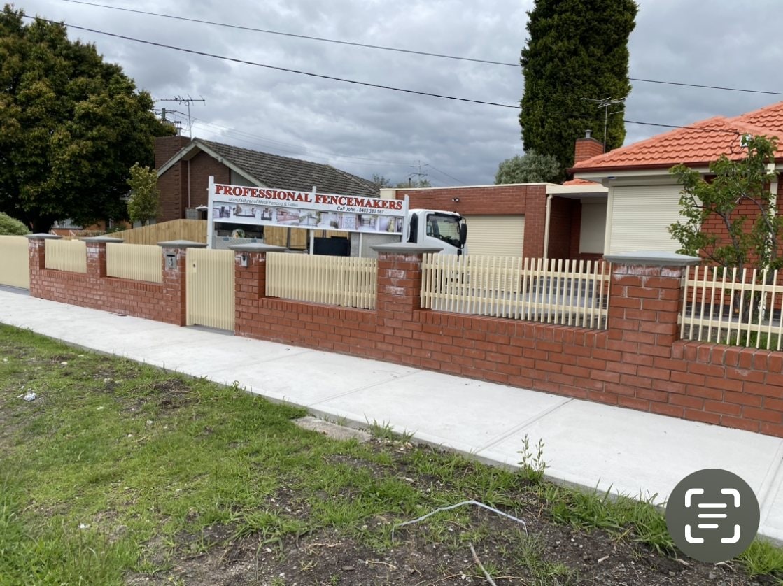 Cream palisade fence with brick piers along a street